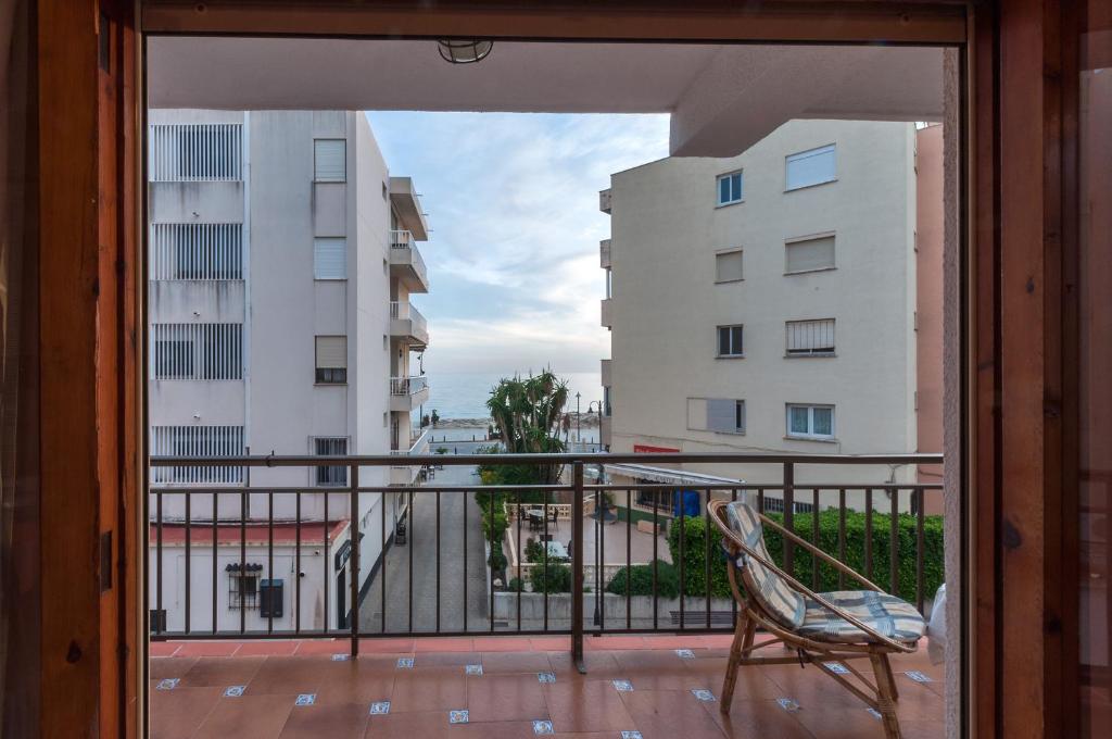 - un balcon avec une chaise et un bâtiment dans l'établissement Sirena, à Moraira