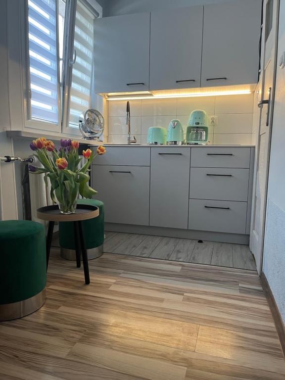 a kitchen with a vase of flowers on a table at Pokoje Gościnne in Kołobrzeg