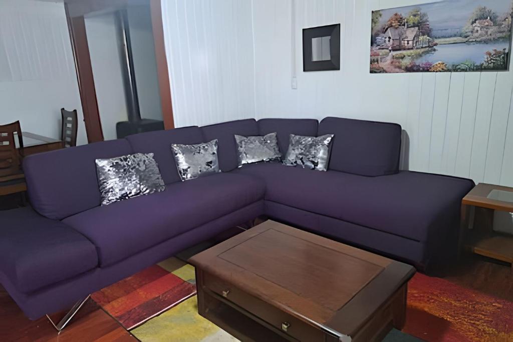 a purple couch in a living room with a coffee table at Casa Barrio estación in Temuco