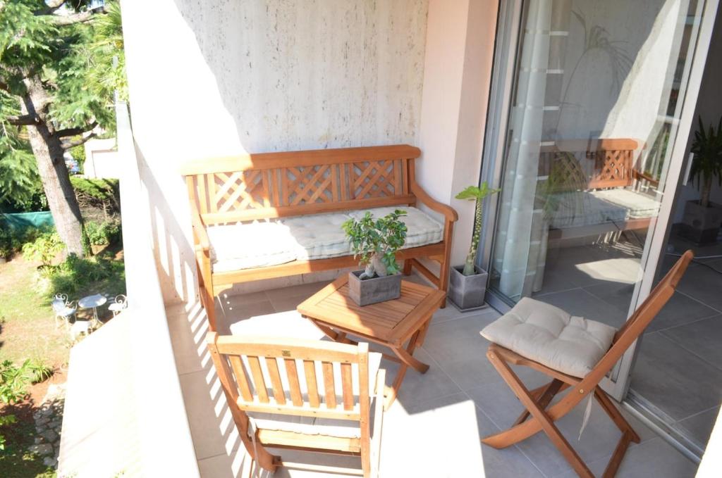 - un balcon avec deux chaises, une table et un banc dans l'établissement Agréable 2p entre Antibes et Juan les Pins, à Antibes