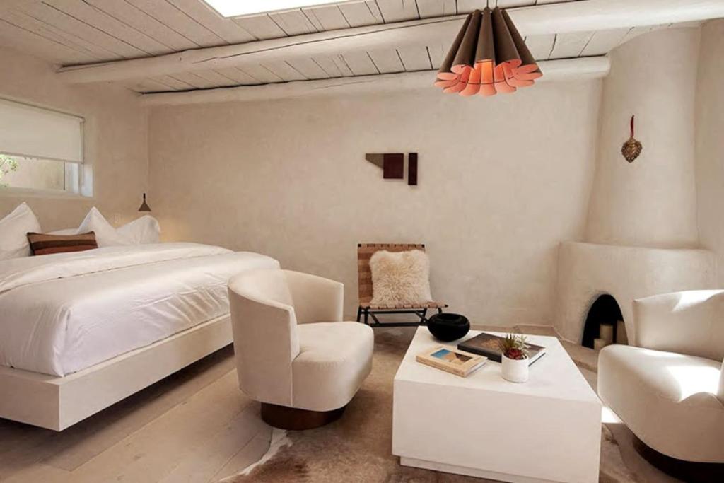 ein Schlafzimmer mit einem weißen Bett und einem Kamin in der Unterkunft Palace Modern Residences at the Railyard - Studio in Santa Fe