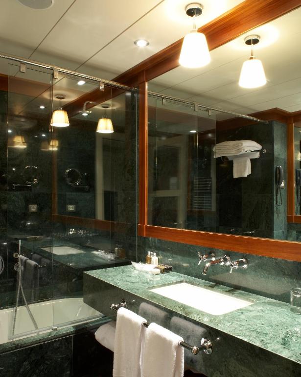 a bathroom with a sink and a large mirror at Hotel 1898 in Barcelona