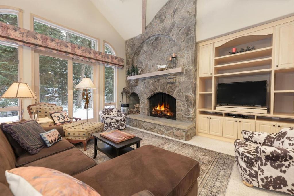 Una sala de estar con chimenea y televisión. en Trailside Mountain Retreat with Private Hot Tub, en Winter Park