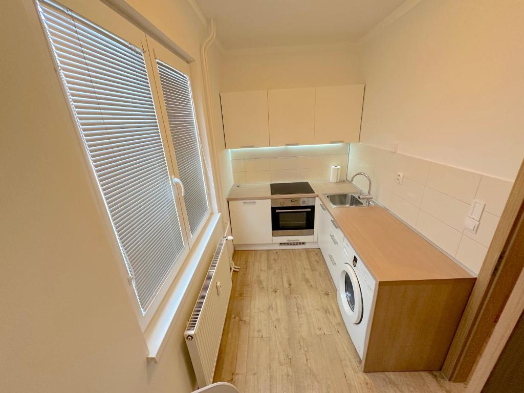 a small kitchen with a washer and dryer at Krásny byt - apartmán v blízkosti centra in Nivy