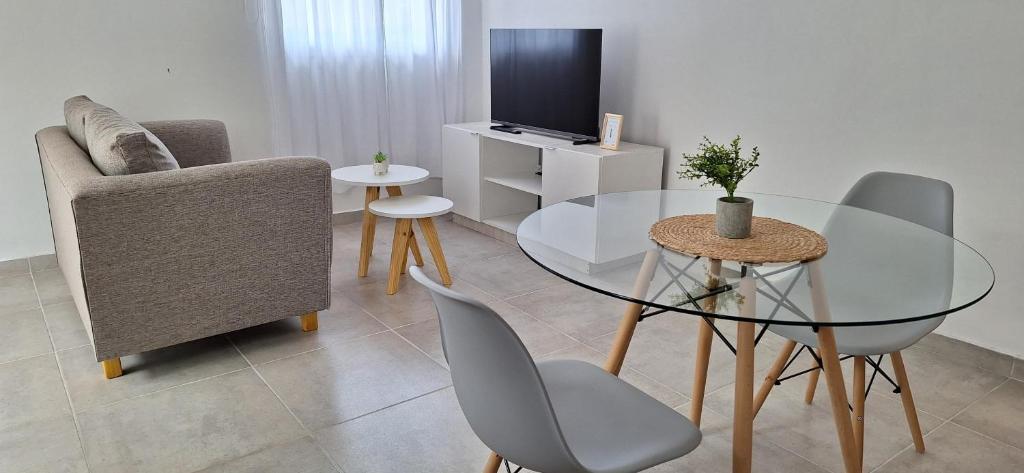 ein Wohnzimmer mit einem Glastisch und Stühlen in der Unterkunft Moderno departamento a estrenar in Alta Gracia