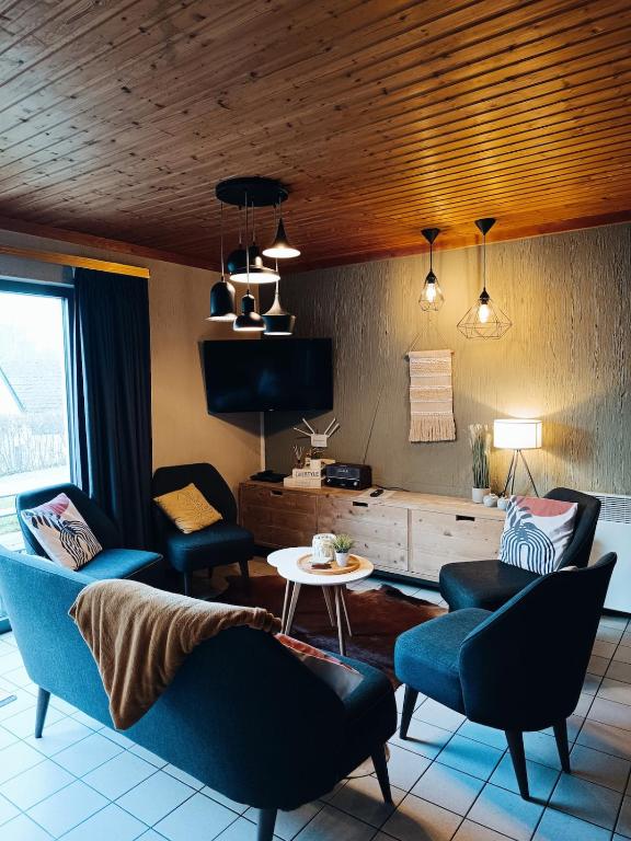 a living room with two chairs and a table at Le havre du lac in Vielsalm
