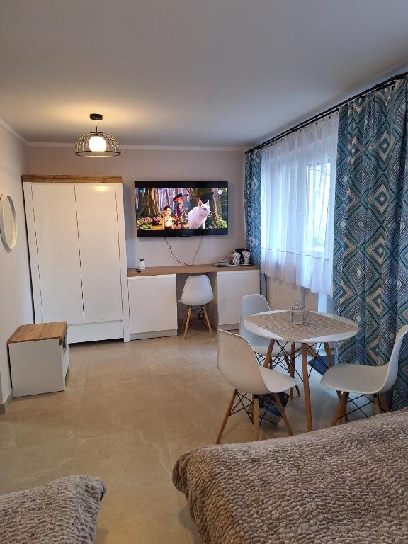 a hotel room with a table and a tv on the wall at Willa Turnia Karpacz in Karpacz