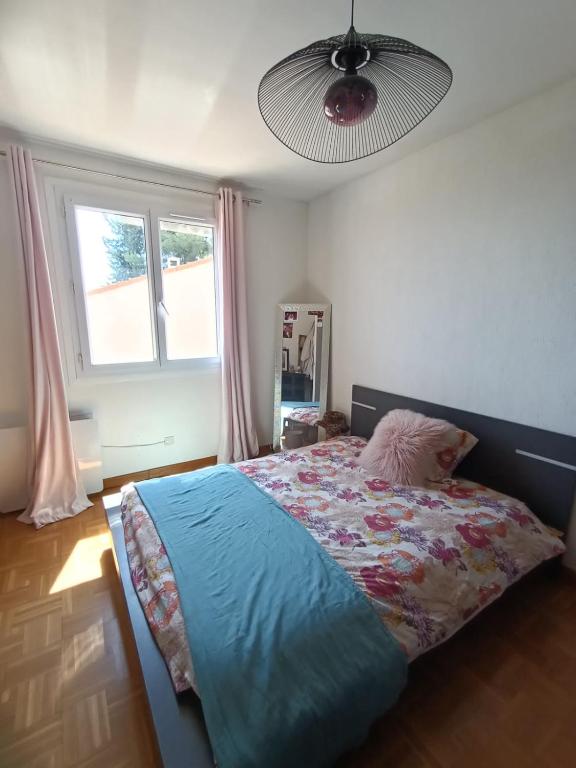 une chambre avec un lit avec une couette bleue et une fenêtre dans l'établissement Villa familiale vue mer, à Carqueiranne