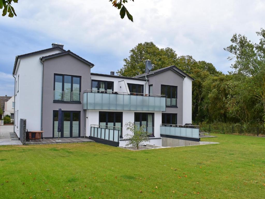 a large white house with a large yard at Exclusives Appartement auf Fehmarn in Petersdorf auf Fehmarn