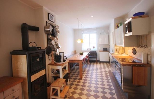 uma cozinha com uma mesa e um fogão num quarto em Ferienhaus Wichmannsdorf em Wichmannsdorf