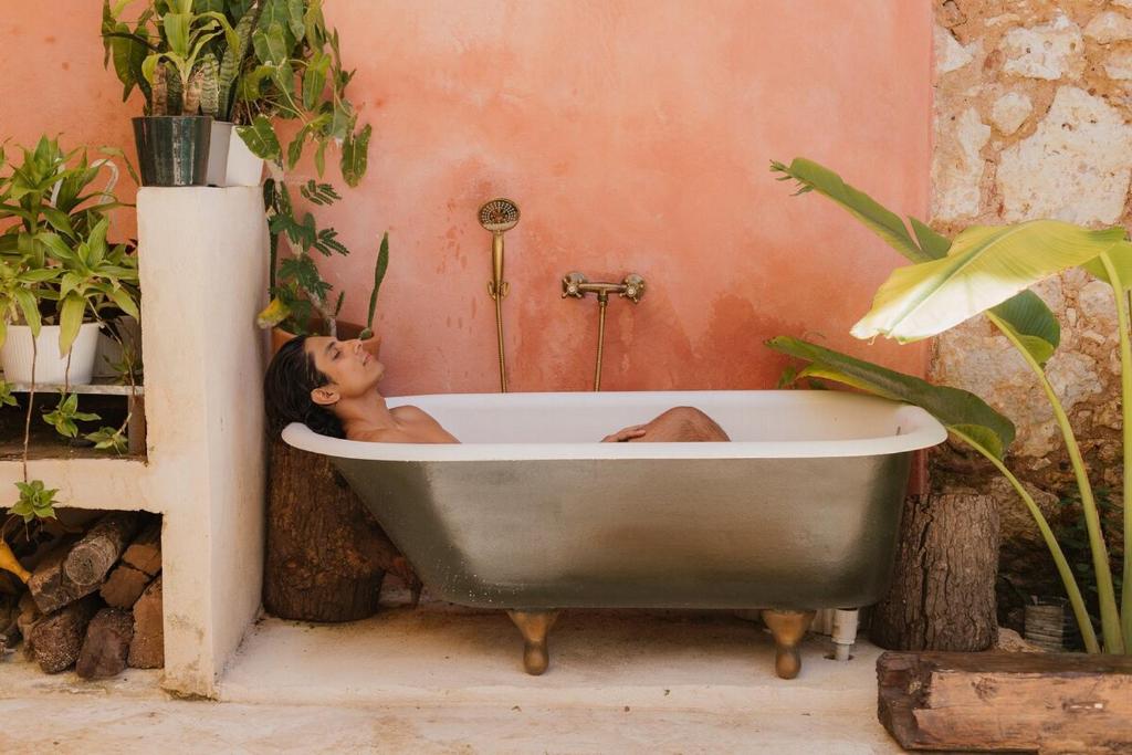 a man laying in a bath tub in a bathroom at Casa Grullon, an Oasis in the Colonial Zone in Santo Domingo