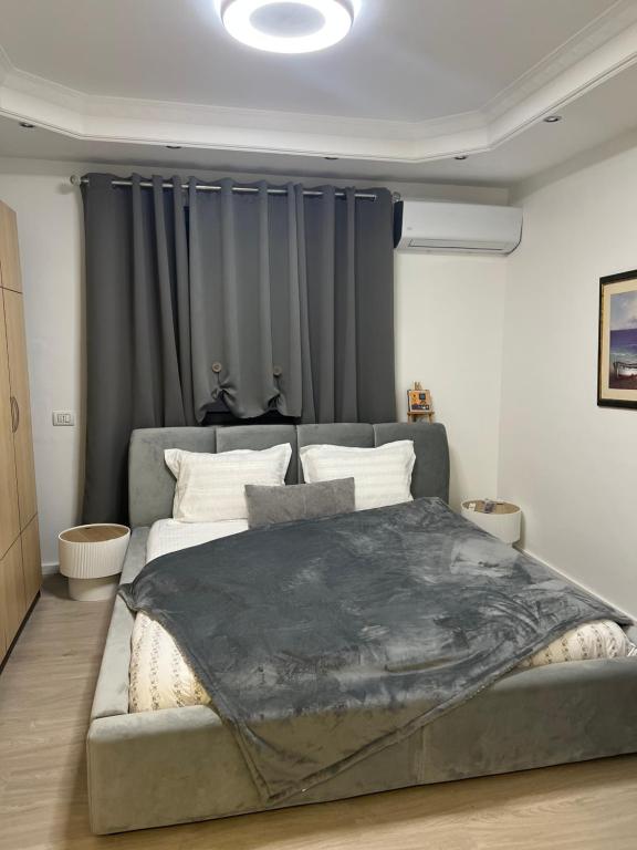 a bedroom with a large bed and a couch at D&D Apartments in Tirana