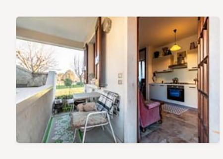a living room with a balcony with a table and chairs at Bilocale Desenzano in Desenzano del Garda
