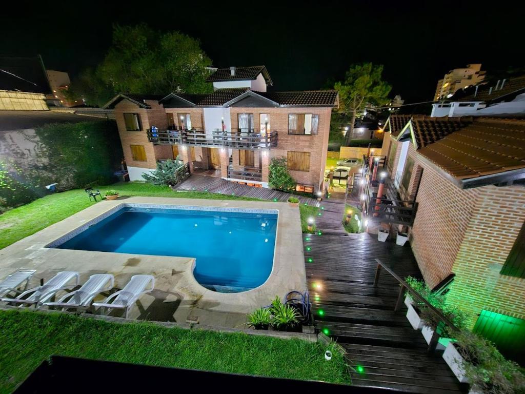 ein Swimmingpool vor einem Haus bei Nacht in der Unterkunft De la Plaza Hotel y Apart in Villa Gesell