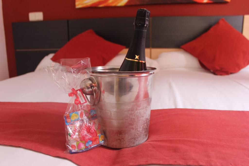 Una botella de vino en un cubo en una cama en Hostal Falfes, en Madrid