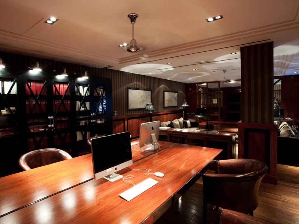 a wooden table with a computer on top of it at Hotel 1898 in Barcelona