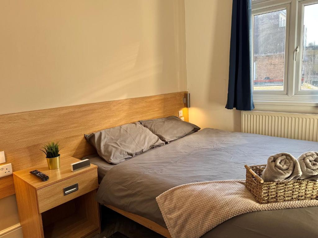 a bedroom with a bed and a table with a basket on it at Stay 45A in London