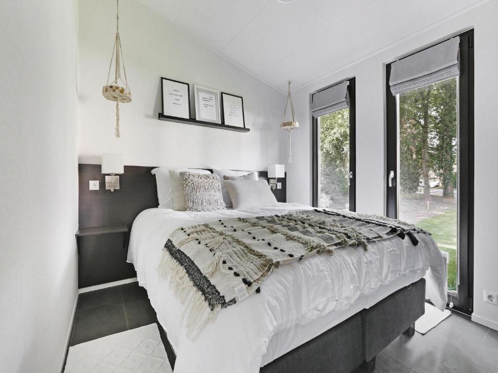 a white bedroom with a large bed and windows at Chalet in Zell am See near Ski Slope in Markelo