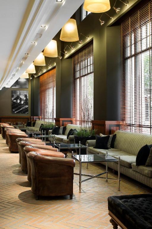 a waiting room with couches and tables and windows at Hotel 1898 in Barcelona
