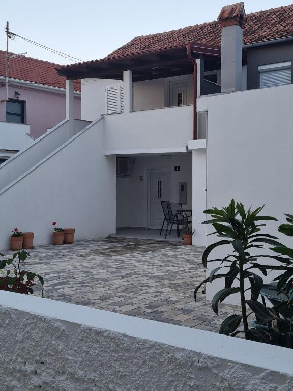 a white house with a patio in front of it at House Dalmatika Zaton in Zaton