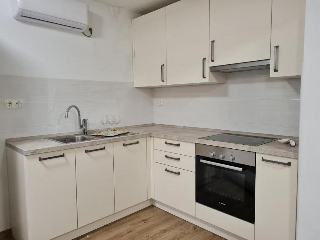 eine weiße Küche mit weißen Schränken und einer Spüle in der Unterkunft House Dalmatika Zaton in Zaton