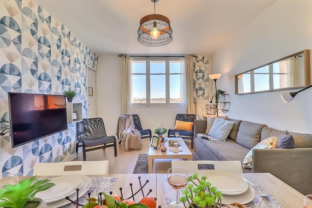 un salon avec un canapé et une télévision dans l'établissement Nyméria, à Nîmes