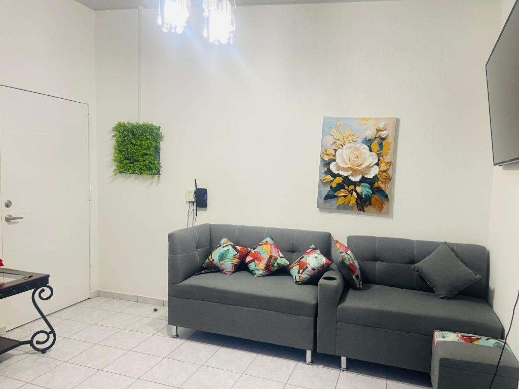 a couch in a living room with a painting on the wall at Casa vacacional san Miguel in San Miguel