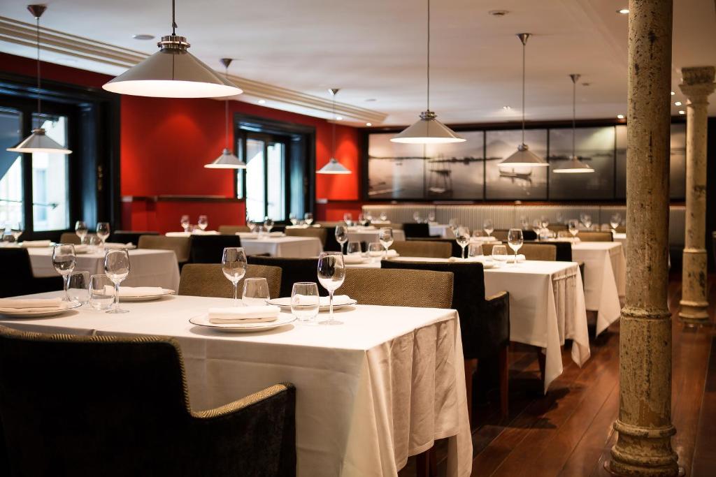 a restaurant with white tables and chairs and lights at Hotel 1898 in Barcelona