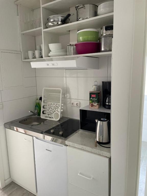 a small kitchen with white cabinets and a sink at TopLageDG in Augsburg