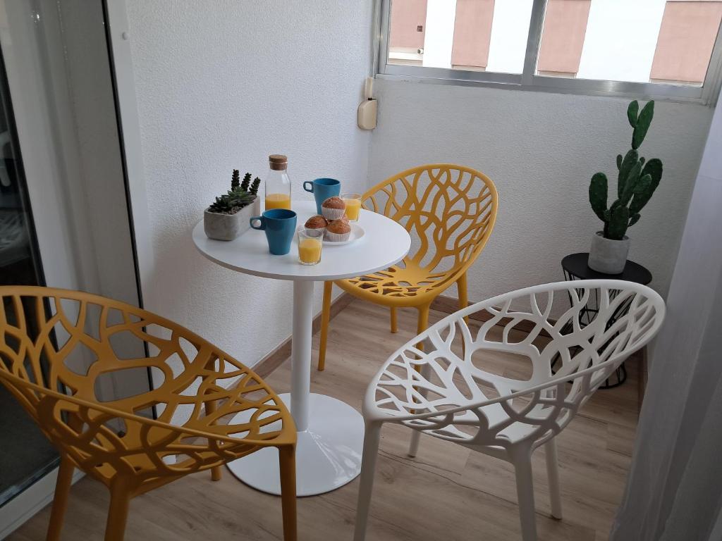 a small table with two chairs and oranges on it at TrendyHomes El Puerto de Almería, próximo Playa y Centro,3 HAB, Espacioso, Familias, Wifi in Almería