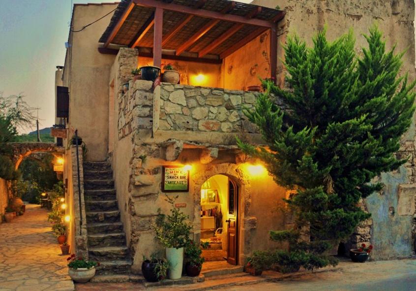 a small building with an entrance with a stone wall at Porfyrousa Traditional Hotel in Milopótamos