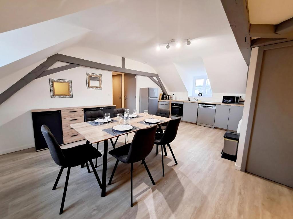 a dining room with a table and chairs in a kitchen at L'Attique, confort, aéré, centre-ville, Netflix in Laval
