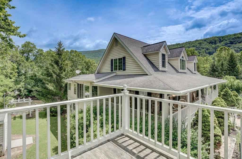 a house with a white railing on a porch at Jackson River Estate Studio Apartment on the River in Covington