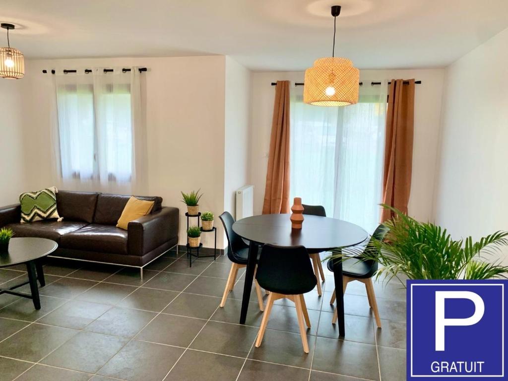 a living room with a table and a couch at 5mn Crolles Chambre au calme parking gratuit - belle cuisine partagée in Froges