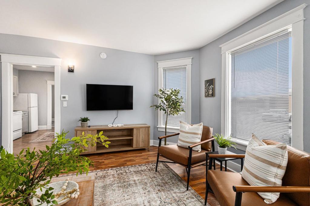 a living room with a flat screen tv and chairs at Remodeled Mins to Beach & Downtown Downstairs in Michigan City