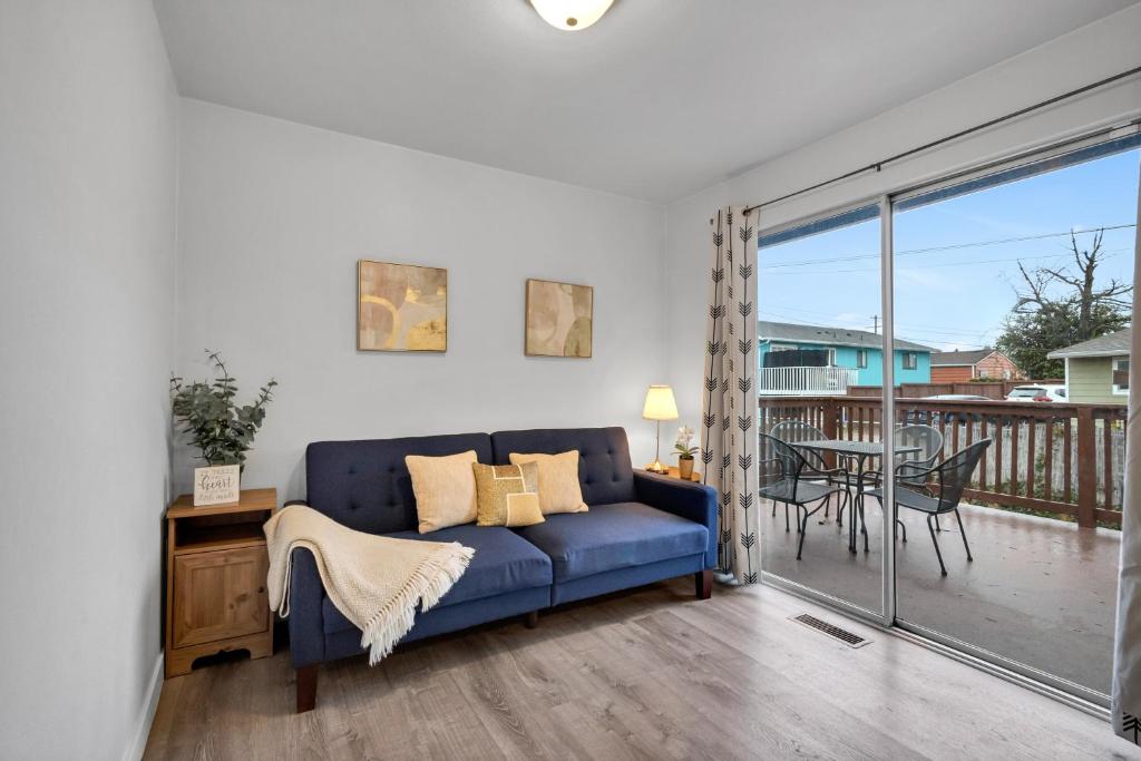 a living room with a blue couch and a balcony at Rainier Entire Upper Floor - Walk to Metro in Seattle