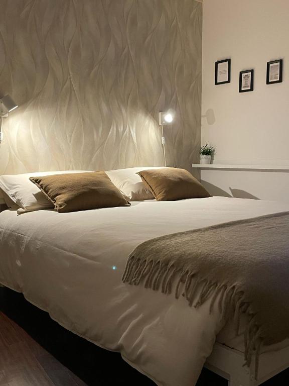 a bedroom with a large white bed with a large headboard at La casa di Erika in Almè