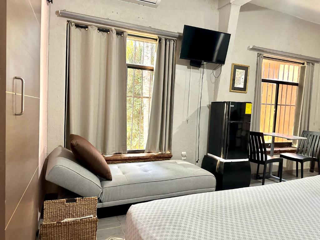 Un dormitorio con una cama, un televisor y una mesa. en Casa Dos Antonios en Zona Viva de Puerto Vallarta, en Puerto Vallarta