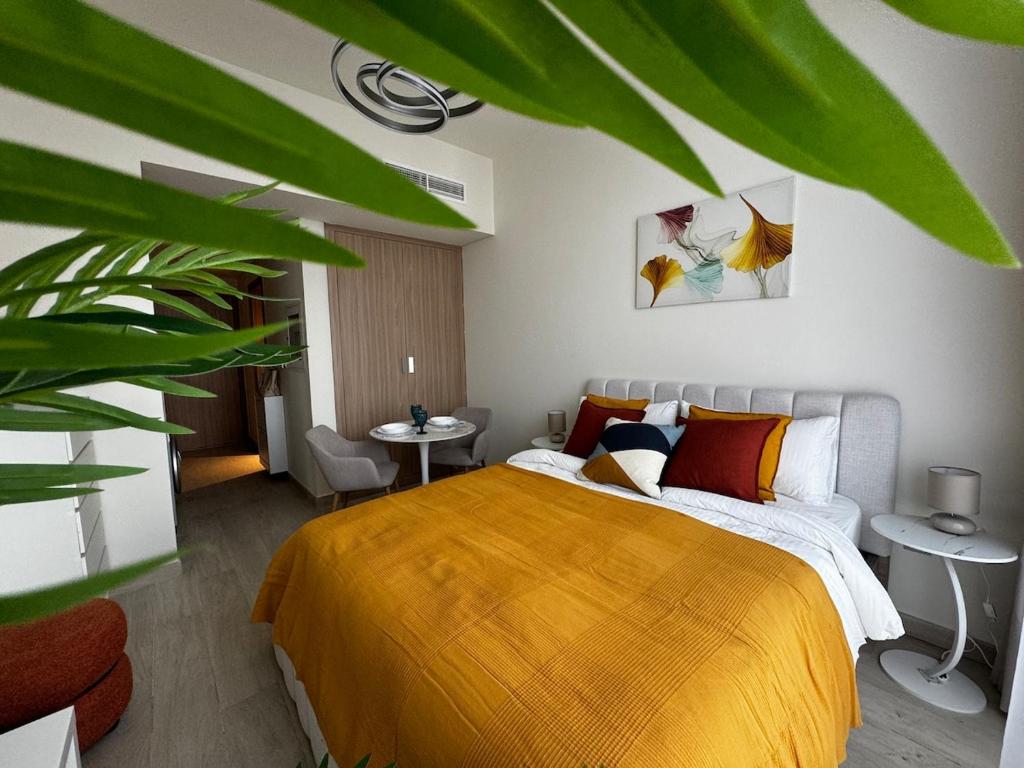 ドバイにあるSunlit serenity Studio Azizi Rivieraの黄色い毛布が掛けられたベッドのある寝室