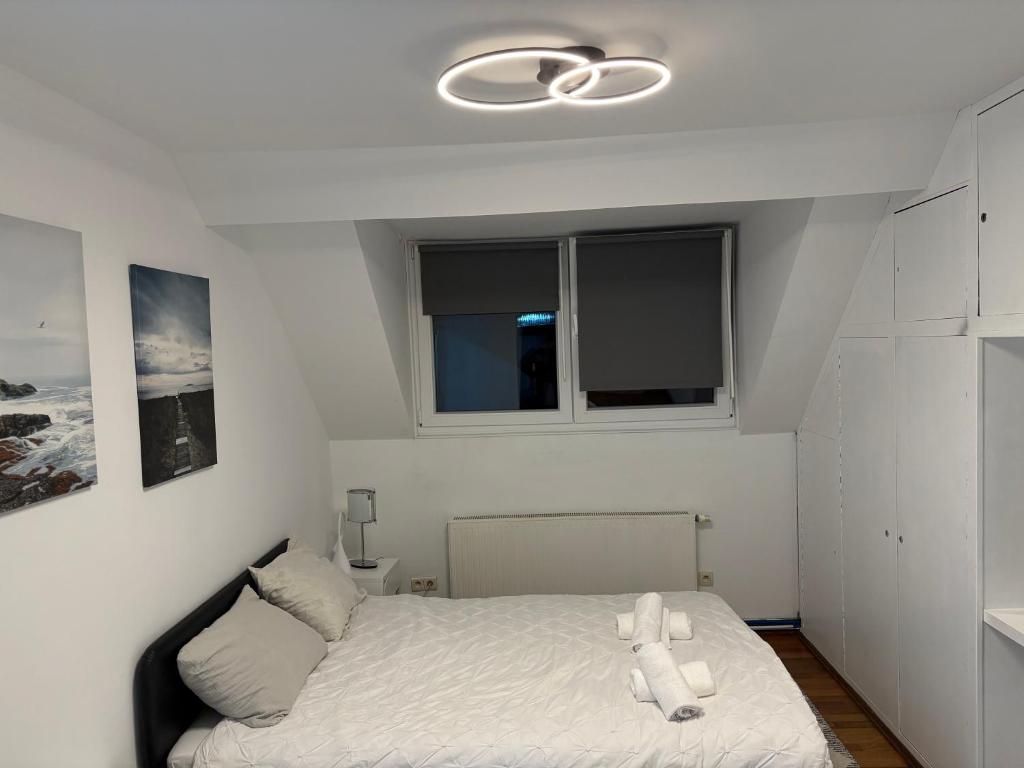 une chambre avec un lit avec des draps blancs et une fenêtre dans l'établissement Cristal, à Bruxelles
