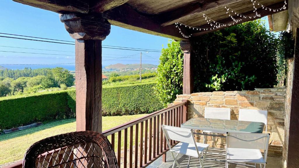 a patio with a table and chairs on a porch at The Cliffs - Vue de Pantin in Valdoviño