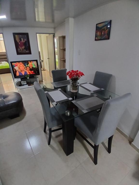 a dining room with a glass table and chairs at Acogedor apartamento en Pereira in Pereira