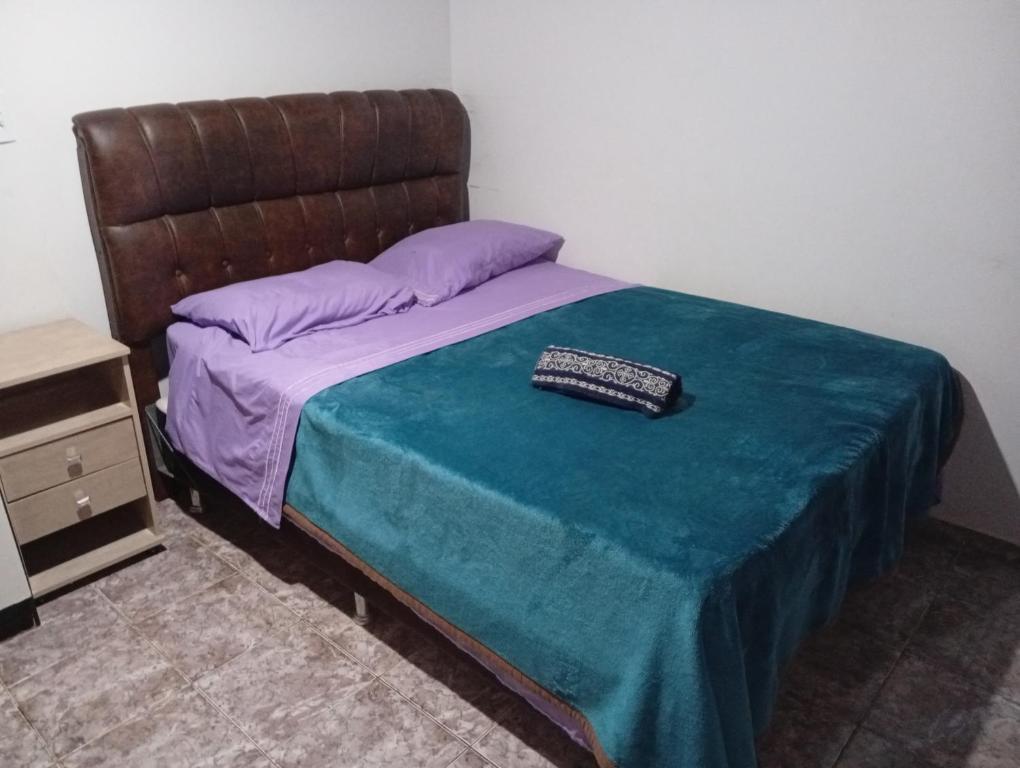 a bed with a blue blanket and a keyboard on it at Linda e aconchegante casa in Toledo