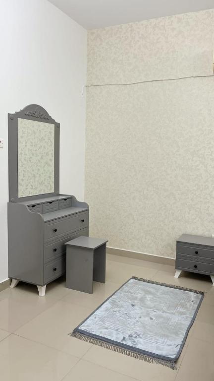 Un baño con lavabo, espejo y alfombra. en درة الغبره, en Mascate