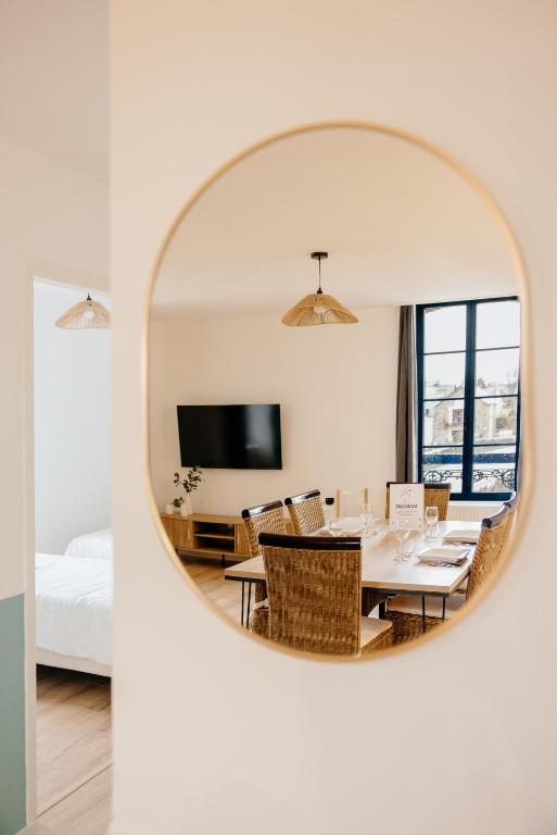 Cette chambre comprend une table, des chaises et un miroir. dans l'établissement L'Atelier du Pont, à Guichen