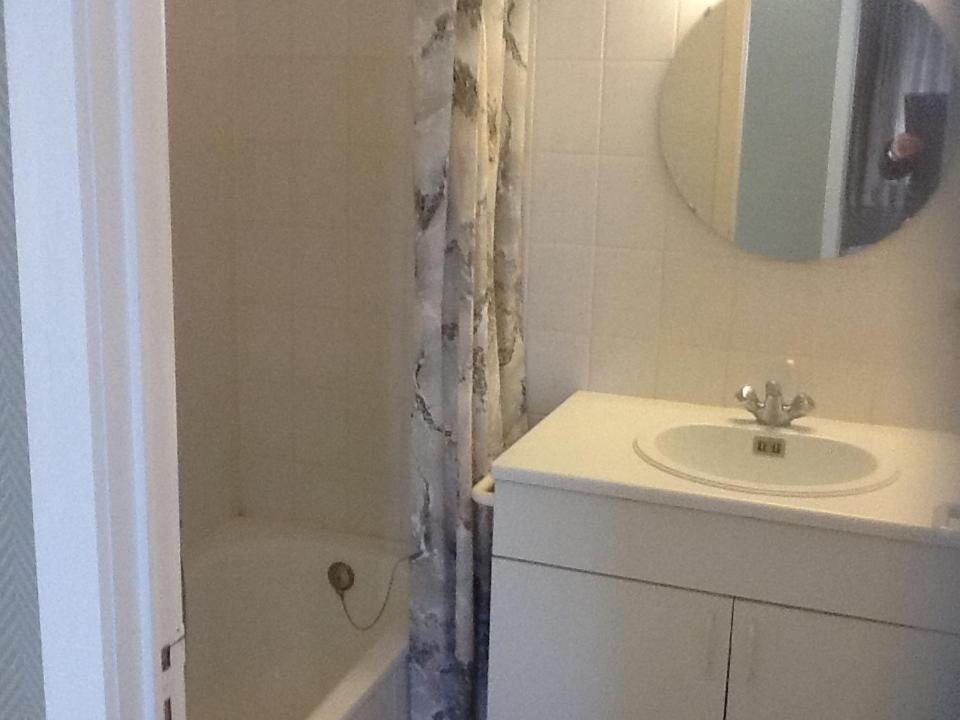 een badkamer met een wastafel, een bad en een spiegel bij Morgenzon Apartment in Nieuwpoort