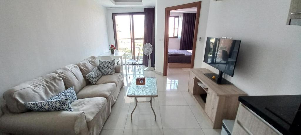 a living room with a couch and a table at Paradise Now in Jomtien Beach