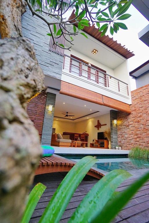 a house with a swimming pool in front of it at Happy Nest Canggu in Tumbak Bayuh