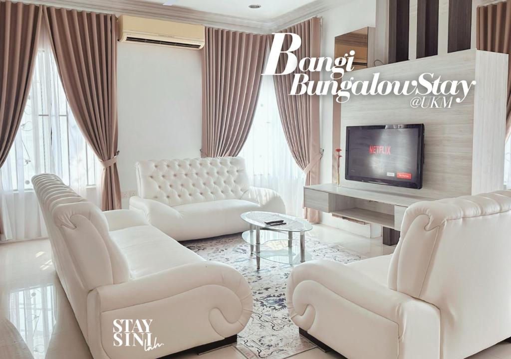 a living room with white furniture and a television at Bangi BungalowStay in Kajang