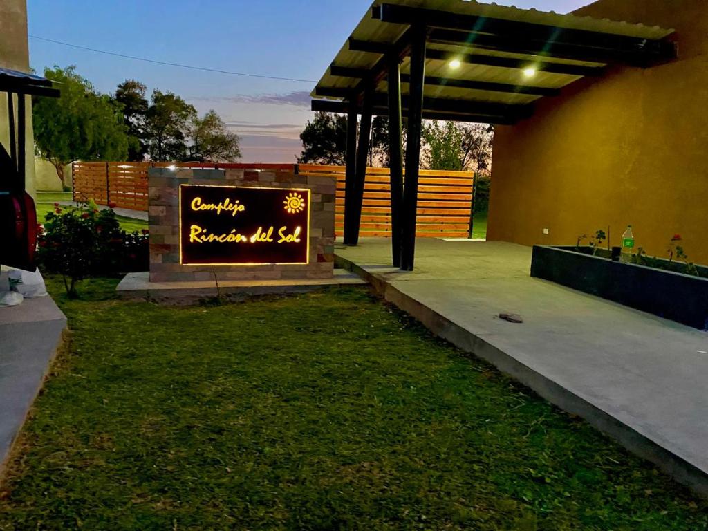 a sign in the grass next to a building at Rincón del Sol en Albardón in Albardón